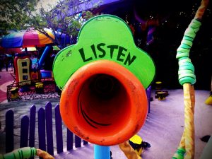 Image of a child's playground with a ride labelled "Listen".