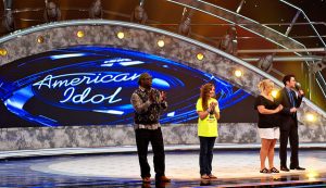 The stage of the television show "American Idol" with contestants standing on stage.