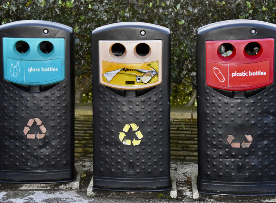 Garbage and bins showing blue, yellow, and red recycling.