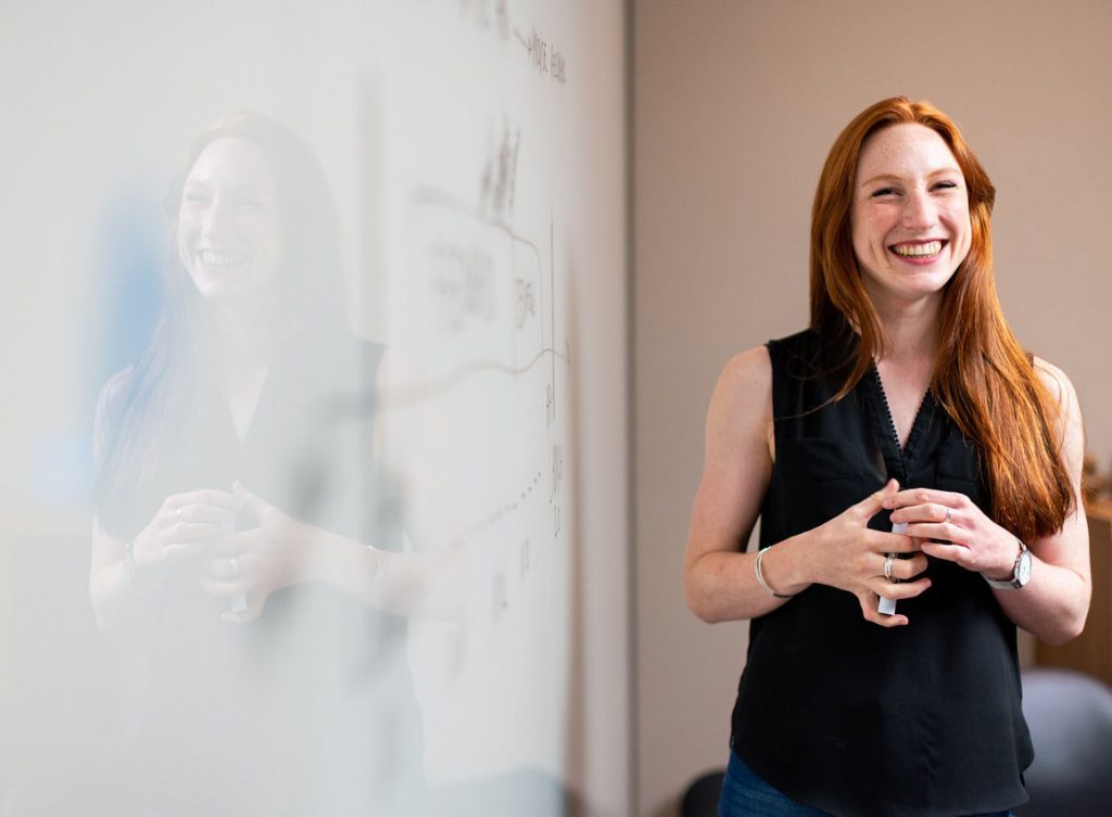 Woman standing by whiteboard.