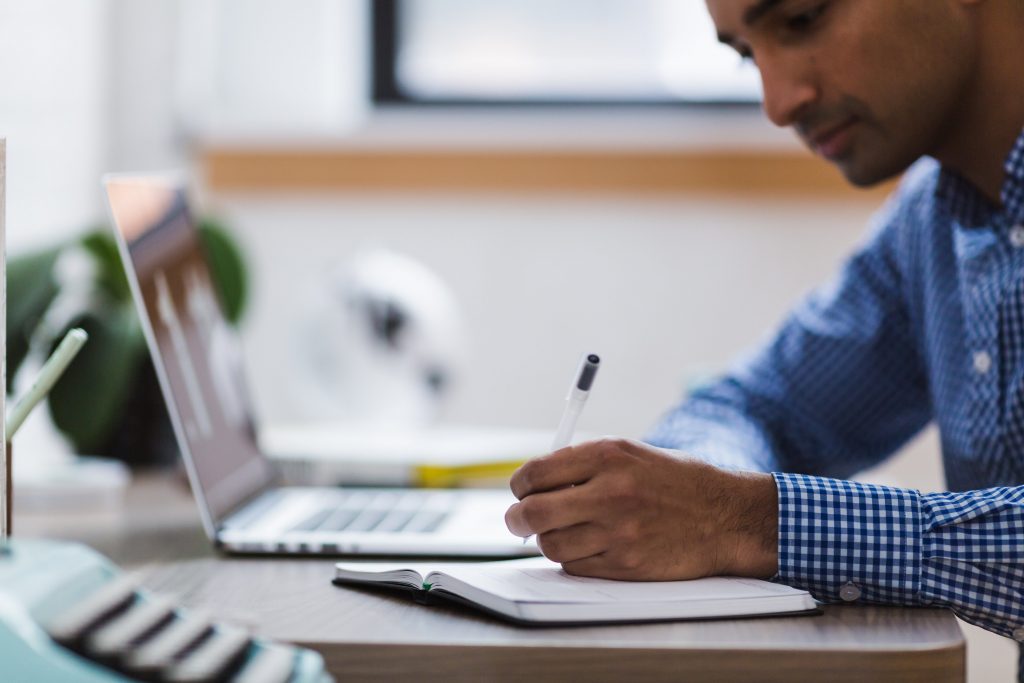 Person working on a computer/writing a report.